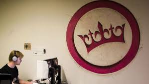 The logo is a pink coloured crown within a circle. Geenstijl Als Radicale Verlichter Trouw