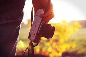 Mężczyzna trzymający aparat fotograficzny podczas zachodu słońca :: Darmowe  zdjęcia