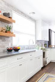 For a touch of color, tuck fresh florals into a decorative vase. A Serene California Cottage In Studio City Homepolish Trendy Kitchen Backsplash Grey Countertops White Kitchen Design