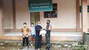 Terlihat satu anak yang lebih besar menggenggam bendera yang sedang berkibar. Kodim 1001 Amuntai Maknai Idul Adha Dengan Salurkan Daging Hewan Qurban Pelopor Wiratama