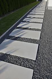 Gartenweg Mit Steinplatten Aus Laenglichen Dunkelgrauen Terrassenplatten Aus Sichtbeton Von Dunklen Kieselsteinen U Gartenweg Terrassenplatten Gartengestaltung