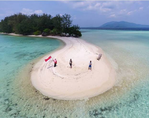 Pulau Cemara Kecil Karimunjawa — hamparan pasir putih mengelilingi pulau tak berpenghuni dengan pohon cemara yang rindang dan laut biru jernih