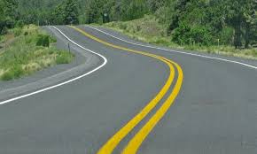 Doble línea continua en Color Amarillo Tráfico en una curva peligrosa, enfatizando Un color que previene accidentes