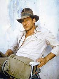 Harrison ford pretends to staple his hat to his head because it keeps blowing off for a particular scene, then they show the scene again and his hat doesn't blow off. Raiders Of The Lost Ark 1981 On The Set Harrison Ford Photo Photo Allposters Com