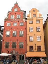 Alice noir @ z.city sunset with alexey sonar. De Twee Rode En Gele Panden Waarin De Cafes Kaffekoppen Links En Chokladkoppen Rechts Zitten Zijn Heel Karakteristiek Voor Gamla Stan Misschien Wel Swedia