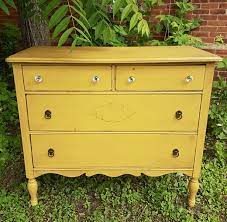A plush mustard yellow seat rests atop of slim steel legs. Antique Mustard Dresser Paint Distress