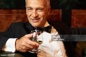 Smiling Senior Man Drinking Brandy Stock Photo