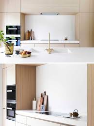 In This Modern Kitchen With Light Wood Cabinets And White Countertops An Integrated Stove Top Sit White Modern Kitchen White Countertops Modern Kitchen Design
