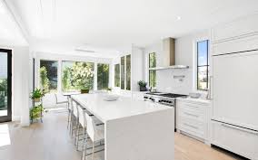 Kitchen islands design is currently one of the hottest trends in the home design industry. Modern White Kitchen With Beautiful Waterfall Island Stepped Drywall Ceiling A True Ge White Modern Kitchen Kitchen Design Modern White Luxury Kitchen Design