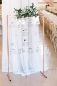 acrylic seating chart with gold easel and greenery