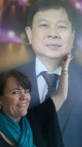 Jackie Anderson with poster of Bernardo Chua, founder of Organo Gold.