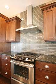I felt that an inverted y shaped chimney hood would pull away from the window and not crowd it like a cabinet/otr would. A Stainless Steel Chimney Hood Over A Tiled Backsplash That Spreads All The Way To The Ceiling Ph Tuscan Kitchen Kitchen Backsplash Designs Kitchen Exhaust