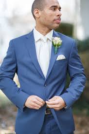 As the third item, you want to choose the tie because that defines what color accents you set and as a fourth, choose the pocket square. Groom In A Blue Suit White Tie And Rose Boutonniere