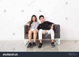 Young Asian Couple Sitting On The Couch Couple Posing Sitting Poses Poses Refers to person, place, thing, quality, etc. young asian couple sitting on the couch