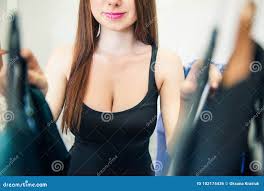 Young Girl with Big Breasts Choosing Clothes on a Rack with Hangers Doing  Shopping in a Showroom. Selection of Clothes of Non Stock Photo - Image of  customer, clothing: 102174436