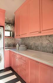 Chic Laundry Room Features Coral Pink Cabinets Paired With White Counter Tops And A Wallpapered Backsplash Pink Laundry Rooms Coral Room Coral Kitchen