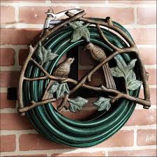 Ideas Amazing Garden Hose Holder Made From Wrought Iron Materials And Have Decorative Designs With Birds Ornaments Hose Holder Garden Hose Holder Garden Hose