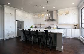 The dark wood floors of this modestly sized but comfortable living room are covered by a natural fiber area rug that lends a nautical feel to the blue and white color pallet. White Kitchen With Gray Island And Dark Floors Transitional Kitchen Oklahoma City By Voelker Photo Houzz