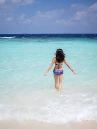 Woman splashing in sea on sunset. Everything You Need To Know About Maafushi Maldives Bel Around The World