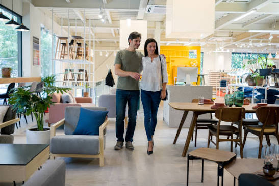 Mauritian couple choosing and measuring quality furniture in a TFP showroom