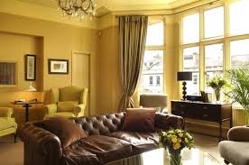 A super bold contemporary space with a yellow wall, a two tone chair, a color block rug and some bright accessories. Home Yellow Living Room Design Ideas