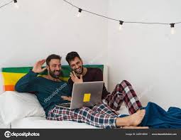 快乐的男同性恋夫妇在床上用笔记本电脑做视频通话同性爱和两性关系平等的概念——图库图片© AlessandroBiascioli 445516650