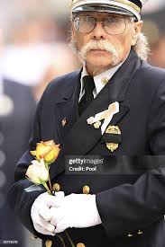 Morganville, N.J. firefighter Bill Cleary holds flowers during the... News  Photo