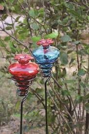 A vacuum feeder has a container that drains the nectar into a reservoir with feeding ports. Glass Flower Hummingbird Feeder W 24 H Metal Yard Stake