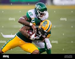 Saskatchewan Roughriders' Jeremy Clark (37) tackles Edmonton Elks' Caleb  Holley (17) during first half CFL action in Edmonton, Alta.,