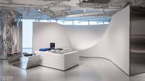 A Divider Inspired By Skate Park Ramps Forms A Backdrop For Tables Of White Ceramic Tile With Green Grout And Polished S Retail Interior Concept Store Interior