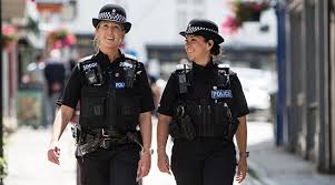 Blue flasher on the police car at night. Careers Surrey Police