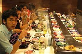 eat at a sushi bar where the plates are on a conveyor belt conveyor belt sushi sushi restaurant sushi bar
