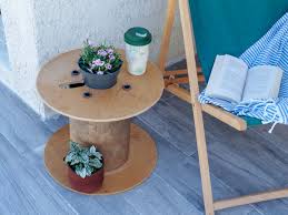 Table basse touret, parée d'un dessin de tournesol et petites bûches décorées en guise de tabourets. Diy Un Touret Recycle En Table D Appoint Stacey Stachetti