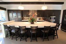 A custom kitchen featuring an island that offers a breakfast bar counter with seats set on the hardwood flooring. Curved Kitchen Island With Seating Bar Counter Galleries General Files Decor