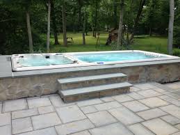 Hydropool Dual Temperature Swim Spa Installed In A Stone Enclosure Learn More About Hydropool Self Cleaning Swim Spa Hot Tub Swim Spa Hot Tub Outdoor Swim Spa