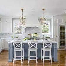 Home styles kitchen island is constructedhome styles kitchen island is constructed of solid hardwoods and engineered wood with a rich white finish. Blue Kitchen Island With White Wood X Back Counter Stools Light Blue Kitchens White Kitchen Design Kitchen Design