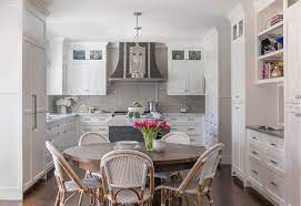 The kitchen seems to go on forever and is filled with charming farmhouse details, like the weathered gray china cabinet and an island with carved wood legs. Classic White Kitchen With Grey Backsplash Home Bunch Interior Design Ideas