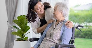 Senior woman and caregiver sitting together in a warm home environment