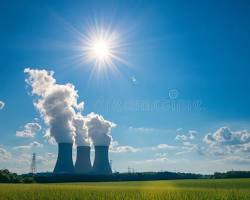 Imagen de nuclear power plant emitting steam into the atmosphere, with a clear blue sky and fluffy white clouds in the background