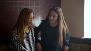 If it's against a law or a rule, of course it isn't ok. Teenage Girls Smoking An Electronic Cigarette In Vape Bar Bad Habit That Is Harmful To Health Young Pretty White Caucasian Teens Vaping Indoors