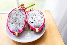 Then, grab either dried cactus cuttings or dragon fruit seeds and plant them flush with the soil line. Closeup Of Cut Open Pink Purple Dragon Dragonfruit Fruit Slices Halves Half Inside White Flesh Seeds Cactus On Plate Wooden Table By Window Stock Photo Adobe Stock