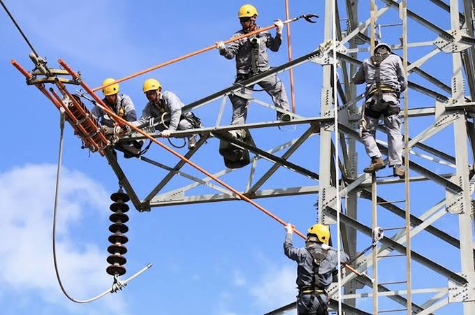 Lignes à haute tension au crépuscule, symbole des défis énergétiques en Afrique