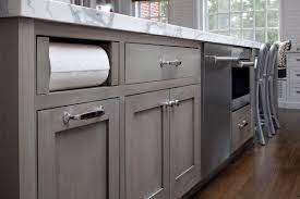 It pairs well with the modern stainless steel accents and the beautiful marble backsplash shown here; Transitional White Kitchen With Grey Blue Stained Island Crystal Cabinets