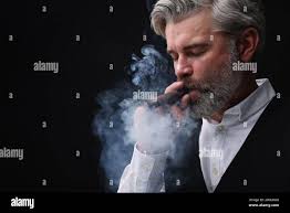 Man with beard smoking cigar hi-res stock photography and images
