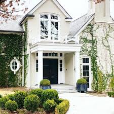 Black And White Brick House Climbing Ivy Beautiful Boxwoods Painted White Brick Stunning Black Front Door White Exterior Houses House Exterior Garage Door Design