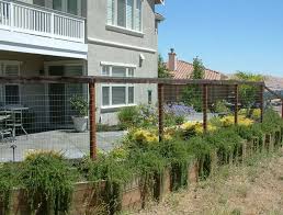 Painted a darker neutral color, it blends into the surroundings making the fence disappear and the natural elements around it take front stage. Wire See Through Fencing Backyard Fences Fence Design Backyard
