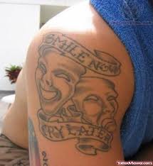 There are few buildings and dark clouds inked on the left side of his chest. Smile Now Cry Later Tattoo On Shoulder
