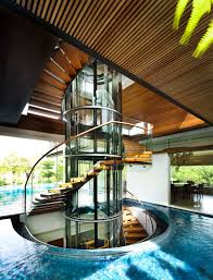 Various spiral staircase designs can be attractively incorporated into large buildings and small homes, landscaping and city architecture. Tropical Home In Singapore With Spiral Staircase Wrapped Around A Glass Elevator Idesignarch Interior Design Architecture Interior Decorating Emagazine