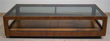 A contemporary interior cannot manage without a modern coffee table. Lot Lane Mid Century Modern Walnut Smokey Glass Top Coffee Table