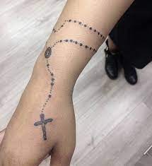 Hypnotic, unique, and intriguing are just a few words to describe this rosary tattoo design that shows an overgrowth of flowers on a crumbling deer's skull. Tendance Tattoo 75 Idees De Tatouage De Chapelet Brillant Et Leur Signification Full Sleeve Tattoos Sleeve Tattoos Wrist Tattoos For Guys